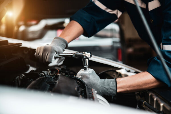 auto mechanic working on a car with wrench
